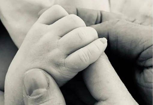 Foto de su mano entrelazada a la de su bebé, con la que anunció el nacimiento