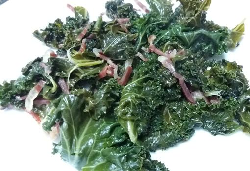 Kale salteado con virutas de jamón.