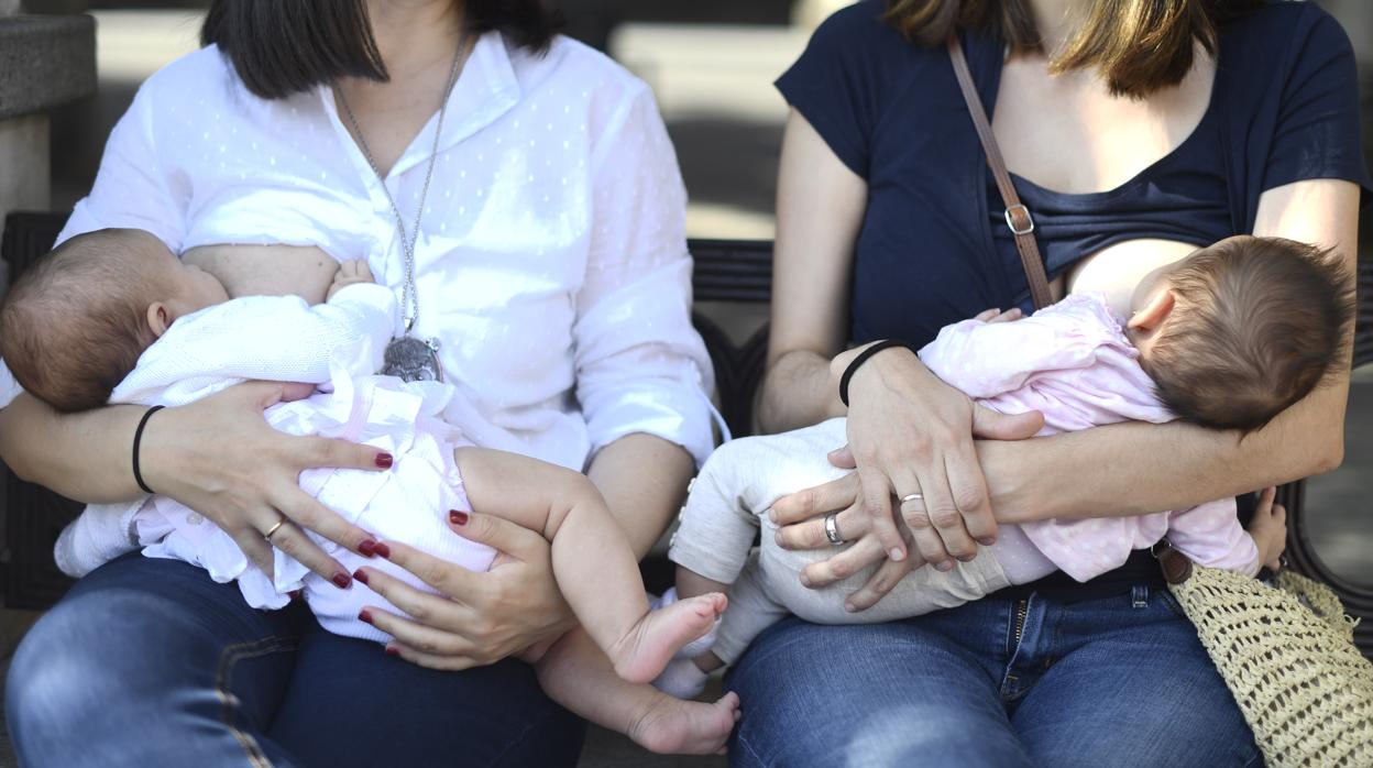 Imagen de archivo de dos mujeres dando el pecho a sus bebés