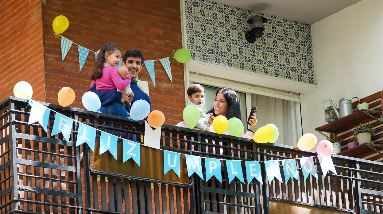 La familia del pequeño Manuel Núñez saluda desde la terraza la llegada de la Policía Municipal de Sevilla para que le felicite por su cumpleaños
