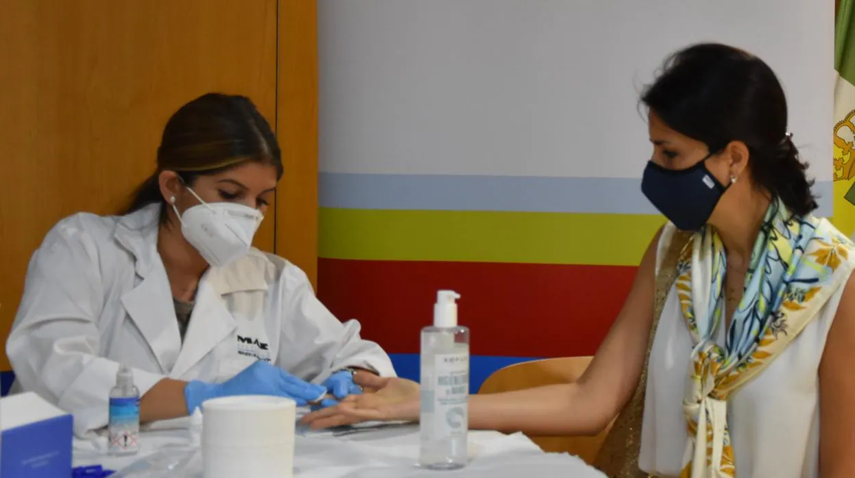 Una sanitaria realiza un test serológico a una docente de CEU