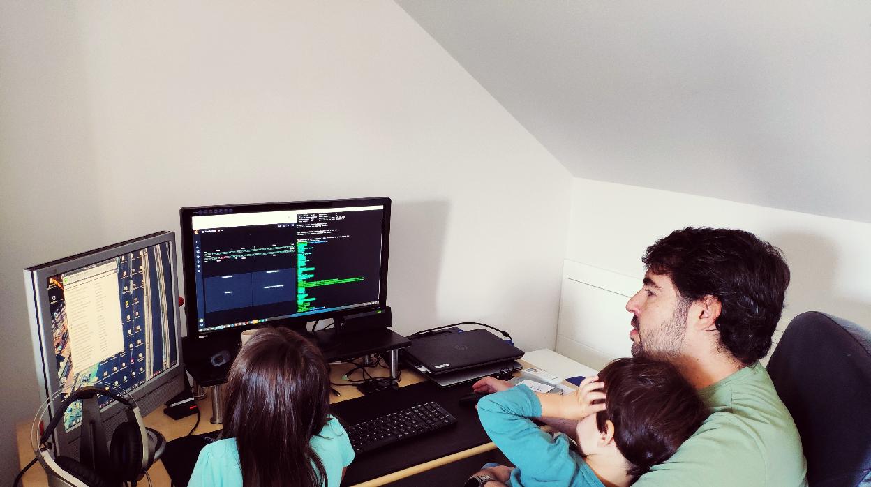 Juan Carlos, con sus hijos, en la oficina que tiene montada en casa