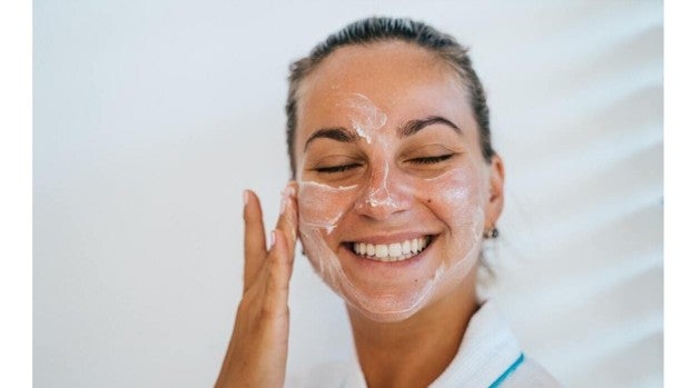 Mujer aplicándose crema en el rostro