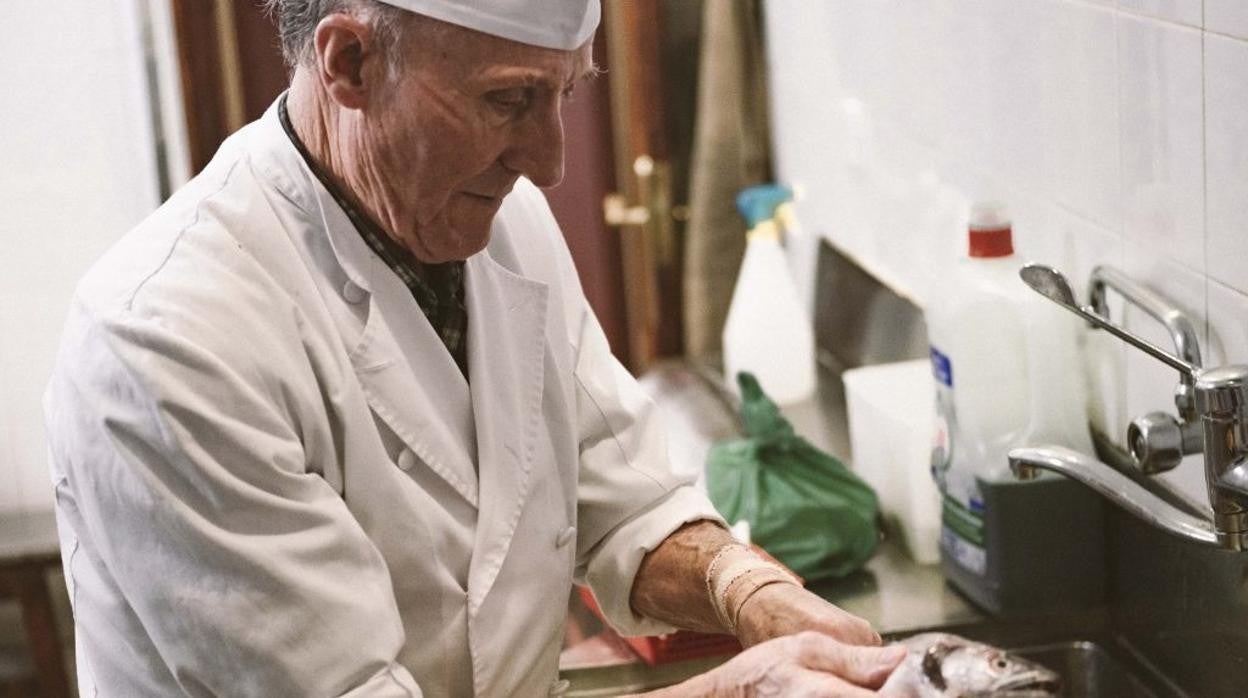 Miguel González limpiando pescadillas en su restaurante El Bierzo, en Chueca