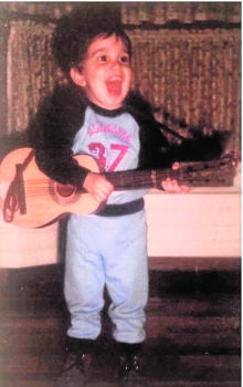 El cantante, de pequeño con su guitarra