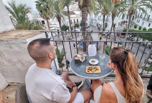 Una pareja, disfrutando de su tabla y sus vinos en la terraza