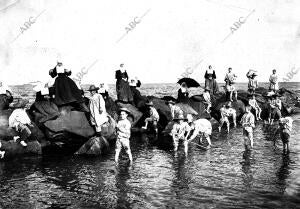 Los niños del asilo de San Eugenio tomando los baños en la playa