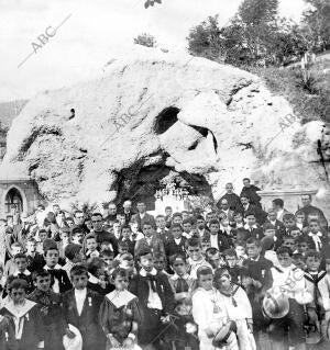 Los niños de los colegios de Bilbao ante la gruta de Lourdes, construida por los...