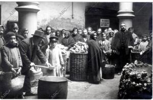 Reparto de comida a los pobres y obreros sin trabajo, de los cuales socorre...