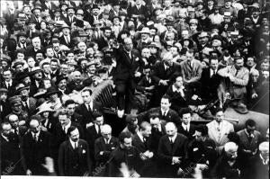 Benito Mussolini, de pie sobre un coche, asiste a un desfile fascista