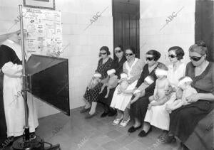 Los niños expuestos a la acción benéfica de la luz ultravioleta, en el regazo de...