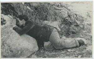 Salvatore Giuliano apoyado en una piedra, mirando por unos prismáticos