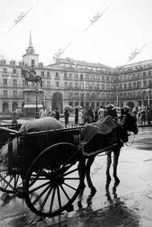 Un coche de Caballos bajo la lluvia en la plaza mayor