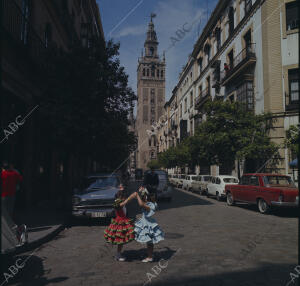(CA.) Niñas vestidas de flamenca, bailando en una de las calles de la capital