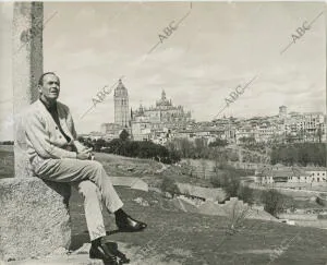 Ante el pasaje urbano de la vieja ciudad de Segovia, Henry Fonda posa sentado al...