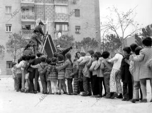 Unos niños hacen cola para usar un tobogán en un parque