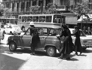 Un policía municipal ayuda a unas monjas a apartar un automóvil averiado en la...
