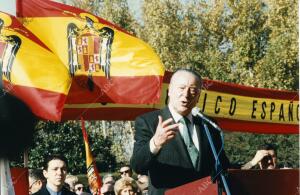 Blas Piñar da un discurso rodeado de banderas