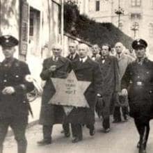 Grupo de hombres judíos obligado a marchar portando una enorme estrella amarilla en público