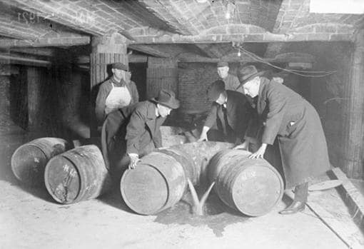 Agentes del gobierno en el acto de confiscar y desechar bebidas clandestinas (Chicago, 1921).
