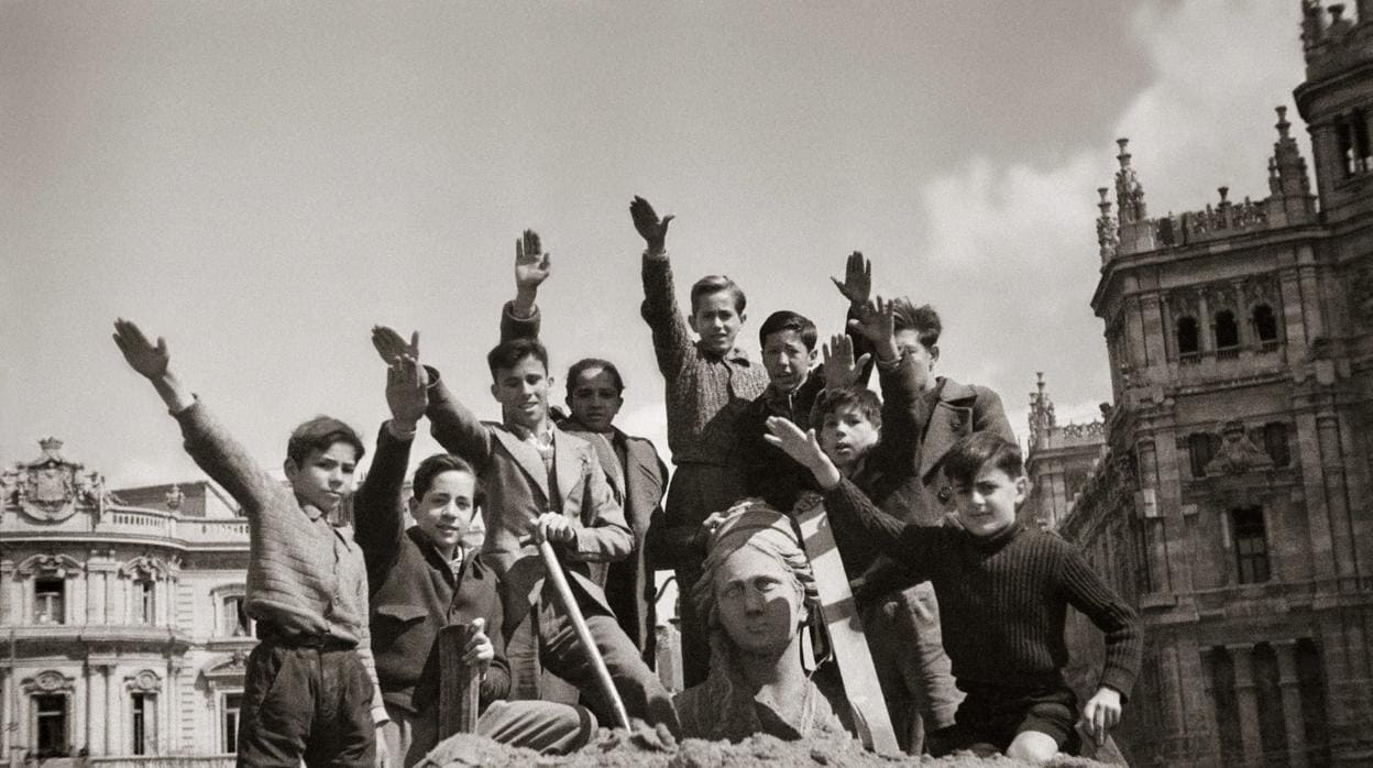 Niños, en alto durante las obras de desescombro de la Cibeles en 1939, que estuvo protegida durante la Guerra Civil, nada más terminar la contienda