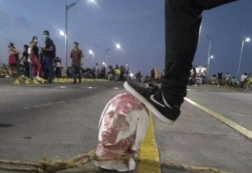 Un joven arrastra una cabeza de una estatua de Colón por las calles de Barranquilla (Colombia)