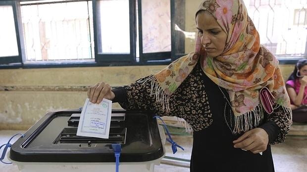 Una mujer introduce su voto en la urna durante las elecciones parlamentarias en un colegio electoral en la zona de Warq en Giza, Egipto