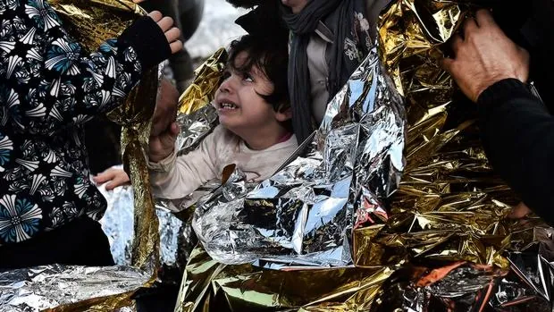 Una niña es abrigada con una manta térmica tras ser rescatada frente a las costas de Lesbos