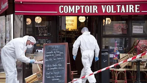 Dos policías forenses trabajan en el escenario de uno de ataques en el Comptoir Voltaire de París