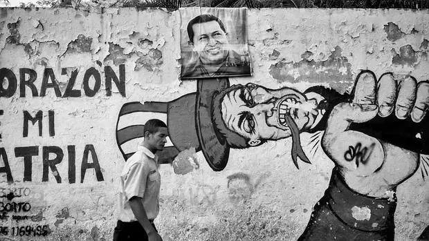Un hombre camina junto a un mural antiimperialista contrario a las políticas Estadounidenses. La figura del Tío Sam con la famosa frase «Yankee Go Home» es una de la pintas más comunes de las calles de Caracas