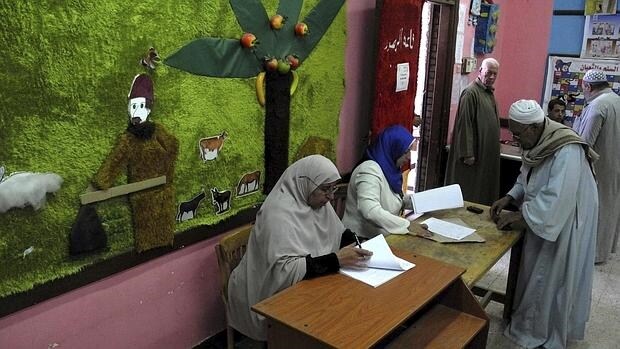 Un hombre se prepara para ejercer su derecho al voto en un colegio electoral en la gobernación de Menufia