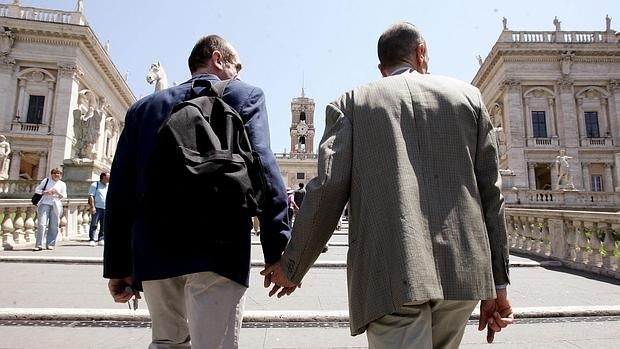 Una pareja gay camina de la mano hacia la plaza Ampidoglio, donde está situado el ayuntamiento de Roma