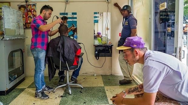 Unos caraqueños hablan sobre los posibles resultados de los comicios en una barbería de la avenida de Andrés Bello