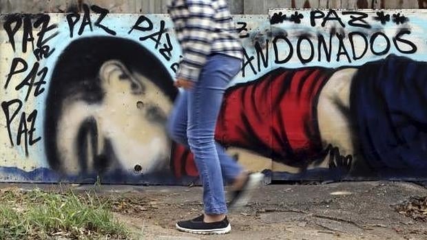 Una persona pasa junto a una pintada que representa el niño sirio ahogado Aylan Kurdi en Sorocaba, Brasil,