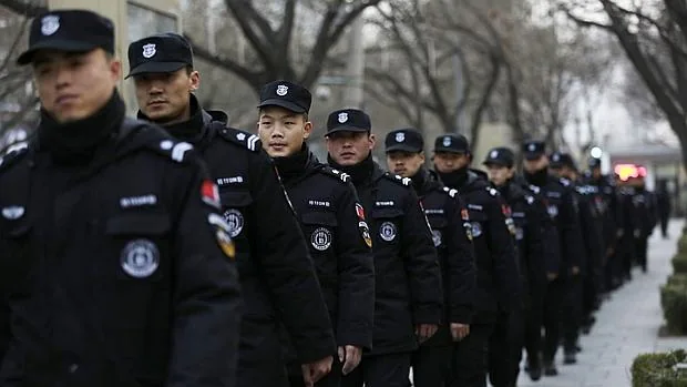 Agentes de seguridad marchan por las inmediaciones de un centro comercial en el distrito de Sanlitun en Pekín (China)