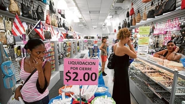 Clientes de un supermercado de San Juan que anuncia su próximo cierre