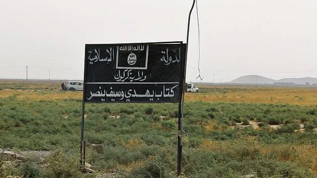 Vista de una bandera y de un cartel de Daesh en Irak