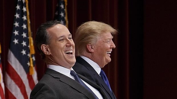 El candidato presidencial republicano Donald Trump (d) ríe junto al candidato presidencial Rick Santorum (i) durante un evento de beneficencia para veteranos en la Universidad Drake en Des Moines, Iowa (EE.UU.)