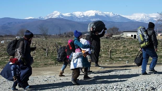 Un grupo de refugiados cruza la frontera entre Grecia y Macedonai en Gevgelija