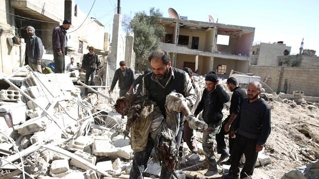 Ciudadanos sirios recogen cadáveres tras un bombardeo ruso en Duma (cerca de Damasco)