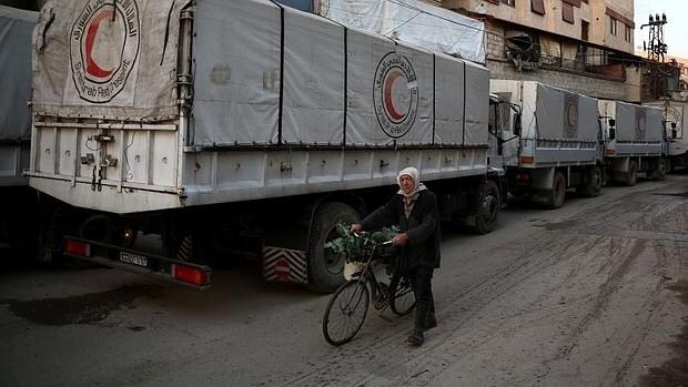 Un hombre pasea alrededor de un convoy de ayuda humanitaria en la ciudad siria de Kafr Batna