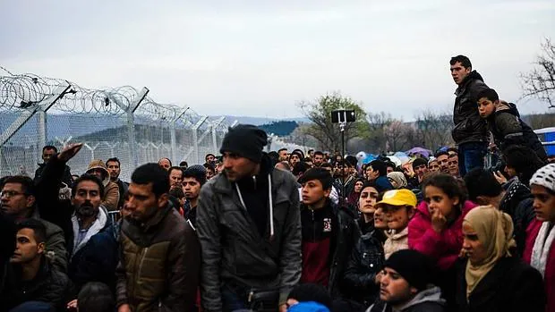 Un grupo de refugiados se amontona en la frontera entre Grecia y Macedonia