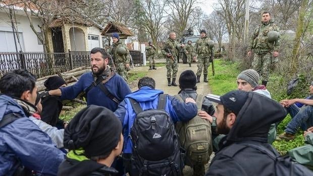 Militares detienen a refugiados que intentan cruzar ilegalmente la frontera entre Grecia y Macedonia, en el pueblo de Moin