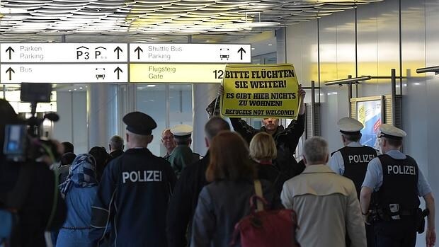 Una persona protesta por la llegada de los refugiados en el aeropuerto de Hannover