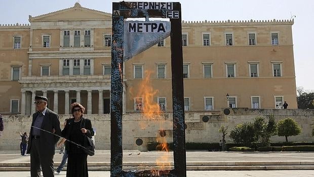 Una guillotina de cartón se alza, ayer, frente al Parlamento griego