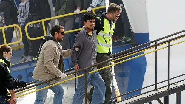 Personal de Frontex acompaña ayer a un refugiado en un ferry turco que sale de la isla griega de Lesbos