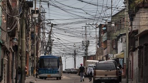 Una pareja camina por en una calle con tendido eléctrico en el sector Catia, Caracas