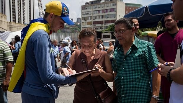 Personas participan en el acto de recolección de firmas para activar el proceso revocatorio al mandato del presidente de Venezuela Nicolás Maduro en la ciudad de Caracas (Venezuela)