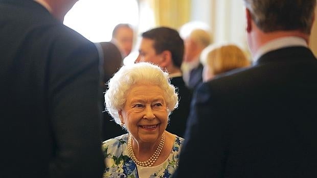 Isabel II sonríe mientras habla con el primer ministro británico, David Cameron, en la recepción que se hizo este martes en Buckingham