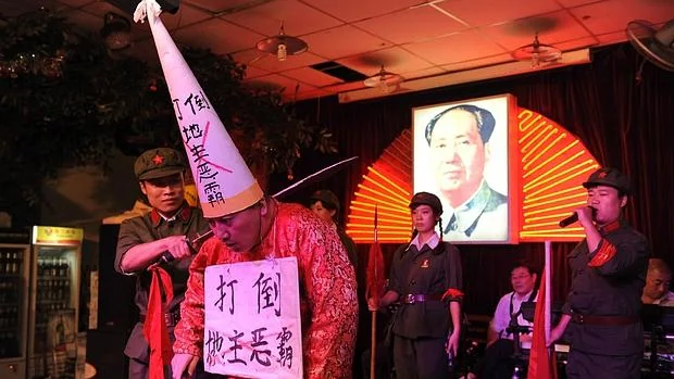 Representación teatral de la humillación y la ejecución de hombre durante la Revolución Cultural en un restaurante de china